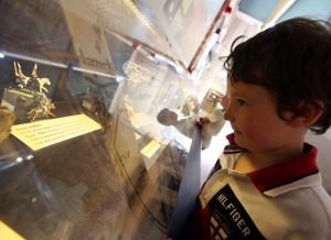 Child looking at small figurines in museum display