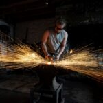 Blacksmith at forge with sparks coming off the metal