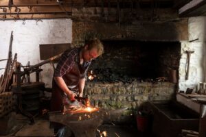 A blacksmith working an an anvil